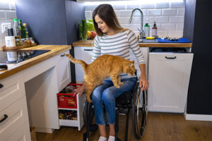 Mulher com deficiência mexendo nos móveis da cozinha